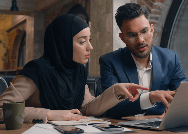 A designer discusses a brochure layout as Arabic Translation Services in Iowa translates business marketing headlines.