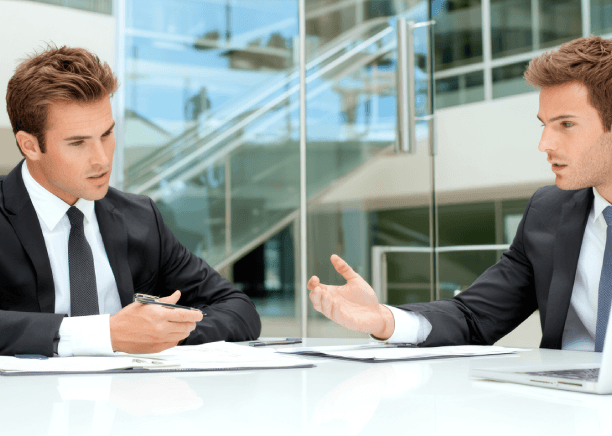 Two business managers review a bilingual contract during a meeting, highlighting Translation Services in Urbandale.