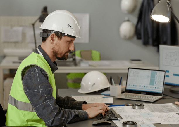 An engineer reviews a Spanish user manual beside schematics, showing Spanish Translation Services in Iowa for certification.
